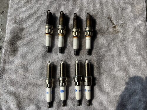 MINIクロスオーバーのエンジン不調修理に伴い取り外したスパークプラグ（劣化品）と新品プラグを並べて比較している写真。 右側が使用済みで電極が黒く焼けている状態、左側が新品部品。