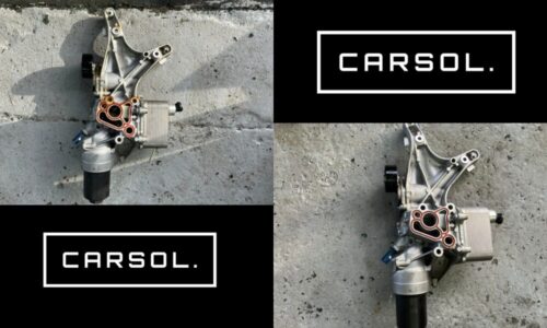 VWパサートヴァリアントのオイルクーラーAssy（オイルクーラー本体とハウジング一体部品）を取り外し、地面に置いた状態の写真。劣化したガスケット部分が確認できる構図。