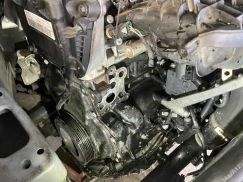 VWパサートヴァリアントのオイルクーラー周辺を取り外した状態のエンジン側面写真。ガスケットを外し、オイル漏れ跡が確認できる作業中の様子。