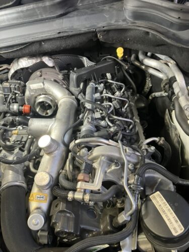 ベンツGLクラス エンジンチェックランプ修理 EGRバルブ交換後 エンジンルーム メルセデスベンツGLクラスのエンジンルーム全体の写真。EGRバルブ交換作業後の状態で、ターボや吸気パイプ周辺が確認できる整備完了後の様子。