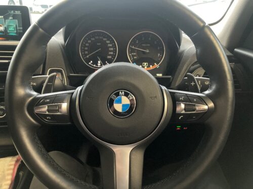 BMW 1シリーズに取り付けたMスポーツステアリングの完成状態。パドルシフト付きステアリングが装着され、交換後の仕上がりや操作スイッチの状態が確認できる画像。